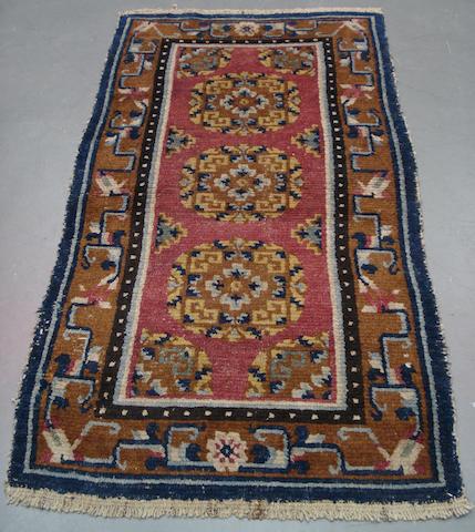 A Tibetan rug 4 ft 5 in x 2 ft x 5 in (134 x 74 cm)