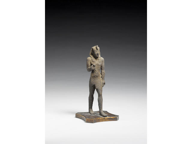 An Egyptian bronze striding figure of a pharaoh