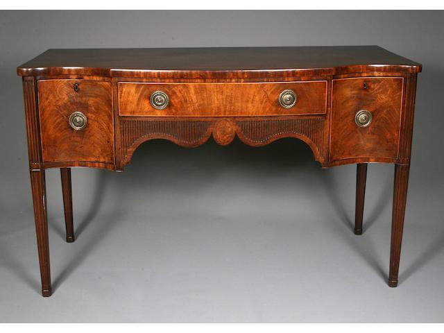 A George III serpentine fronted mahogany sideboard