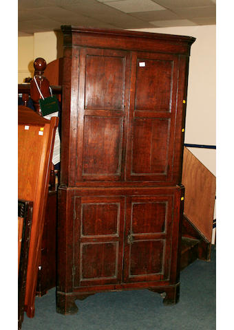 An early 19th Century oak floor standing corner cupboard