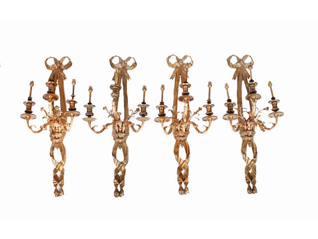 A set of four early 20th century gilt metal three branch wall light fittings