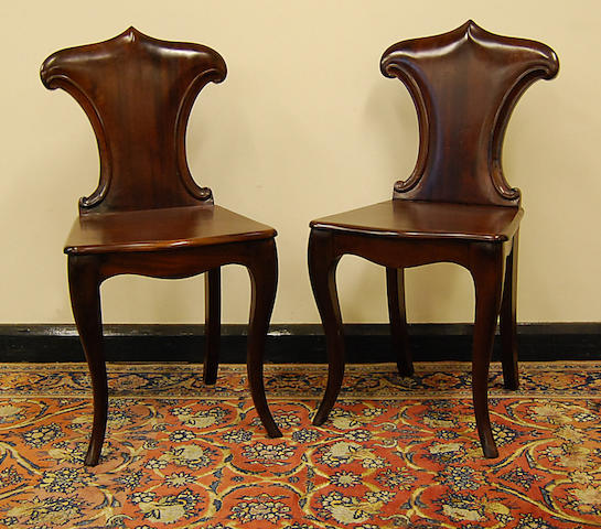A pair of early Victorian mahogany hall chairs