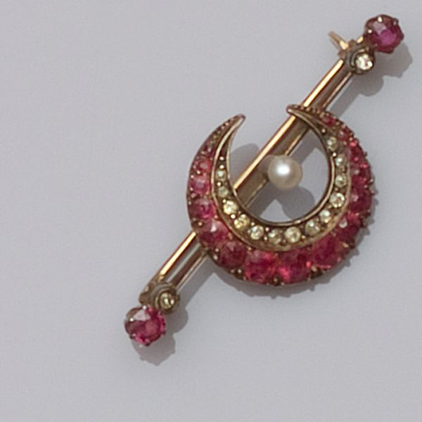 A diamond and ruby set crescent brooch
