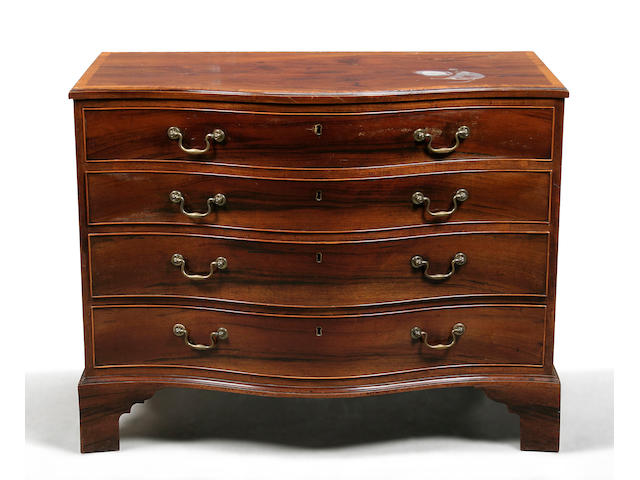 A George III mahogany and satinwood crossbanded serpentine chest circa 1770