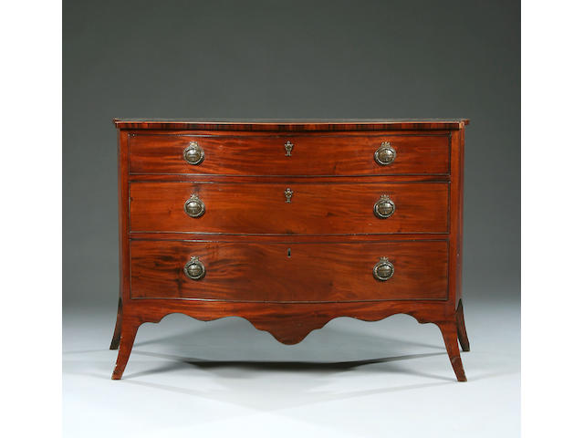 A George III mahogany serpentine Dressing Chest in the manner of John Cobb