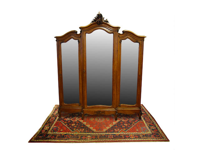 An impressive French carved walnut and quarter-veneered breakfront triple mirror-door wardrobe, late 19th Century