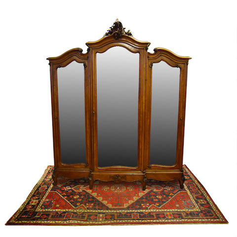 An impressive French carved walnut and quarter-veneered breakfront triple mirror-door wardrobe, late 19th Century