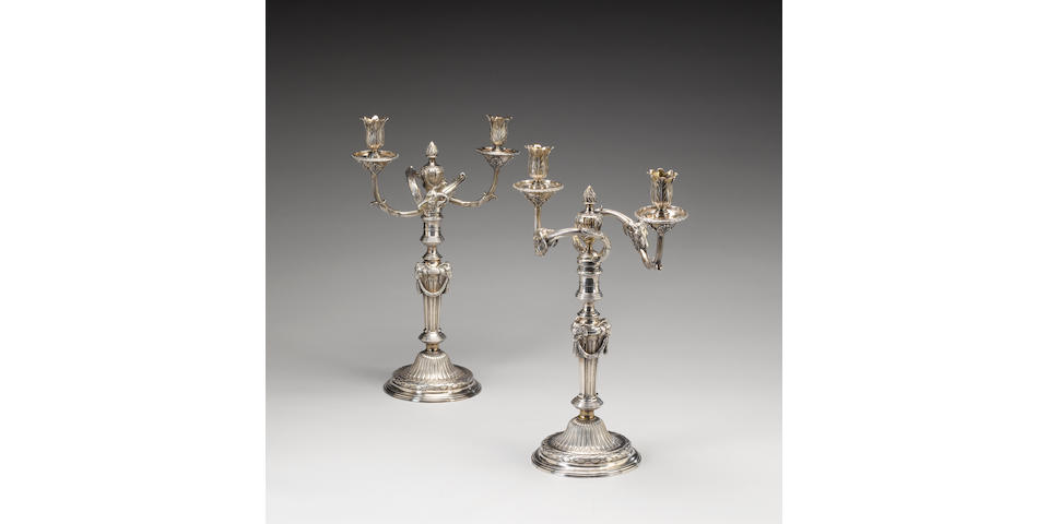 A pair of George III cast silver two-light candelabra in the manner of Robert-Joseph Auguste, by Parker & Wakelin, London 1771, sticks fully marked and detachable branches stamped with lion passant only to each capitol