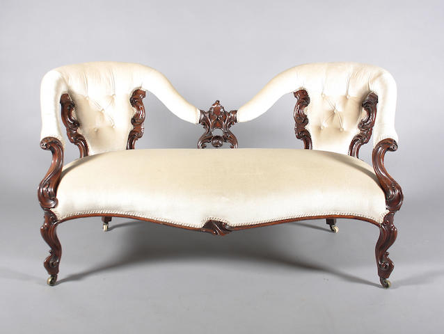 An early Victorian foliate carved rosewood frame upholstered settee