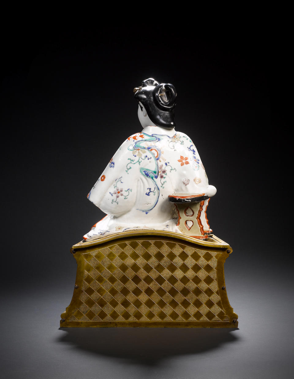 A rare ormolu-mounted Kakiemon model of a seated bijin The figure Japanese, Edo Period, circa 1670-1680, the ormolu mount French, probably Transitional-Louis XVI, circa 1760-1770, the plaque Chinese Kangxi, early 18th century
