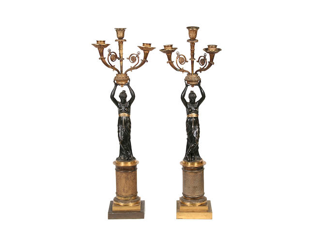 A pair of 19th century Empire style gilt and patinated bronze figural candlesticks