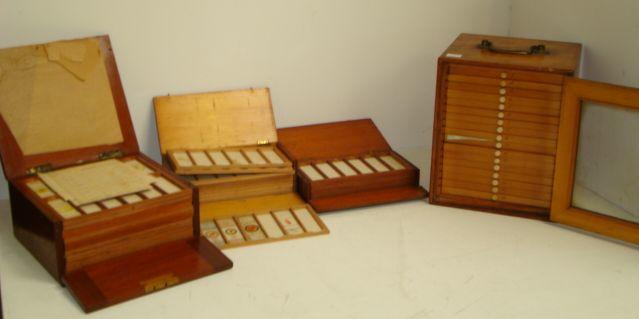A Victorian stained pine microscope slide cabinet, fitted with 17 drawers containing a collection of slides, enclosed by a glazed panel door, brass carrying handle, 25cm, a mahogany example, the hinged top and fall front enclosing twelve trays of glass microscope slides and two smaller similar, one in mahogany, the other in pine.