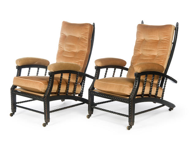 A pair of late 19th Century ebonised reclining easy armchairs of Aesthetic/Arts & Crafts style