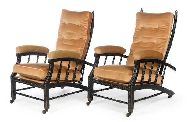 A pair of late 19th Century ebonised reclining easy armchairs of Aesthetic/Arts & Crafts style