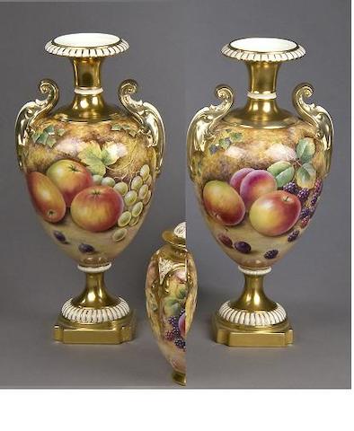 A pair of Royal Worcester twin handled urns signed David Fuller