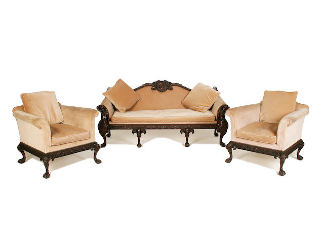An early 20th century carved mahogany sofa and pair of en-suite armchairs by Maples after a design by Robert Adam or John Linnell