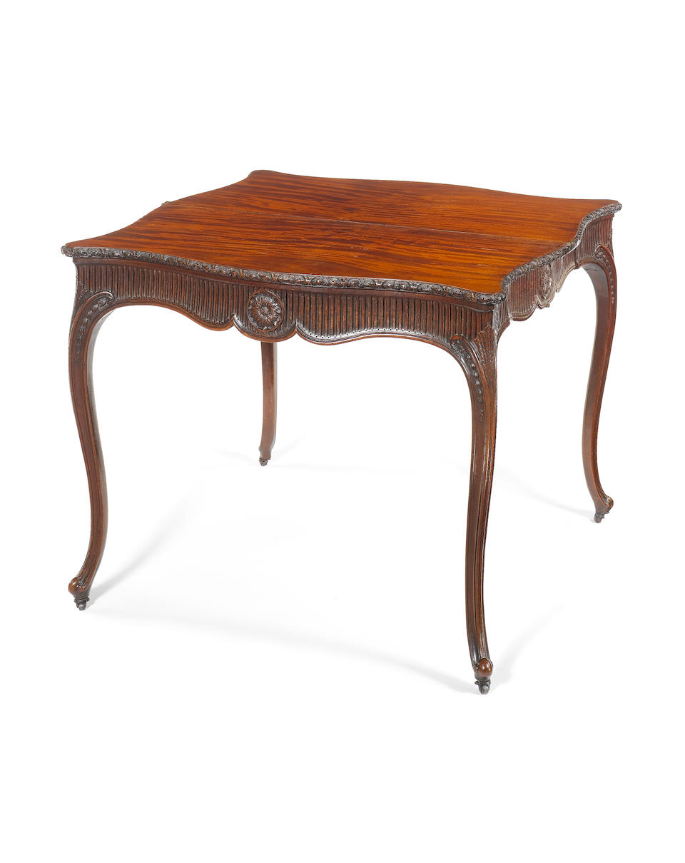An important George III carved mahogany serpentine concertina-action tea table in the French Hepplewhite taste