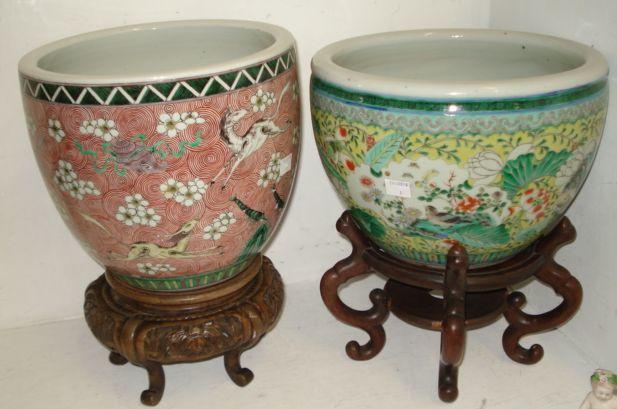 An early 20th Century Chinese planter bowl, decorated in a famille verte pattern, 29cm, another decorated with running animals on a red spiral ground, and two wooden stands, 26cm.
