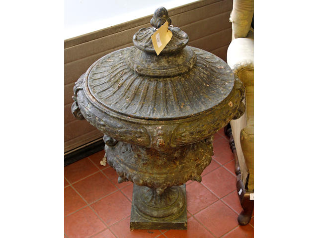 #A pair of French cast iron terrace urns and covers, each of scroll handle campana form moulded with bands of laurel on slender square pedestal bases, 66cm high, 25.5" high) 51cm diameter.
