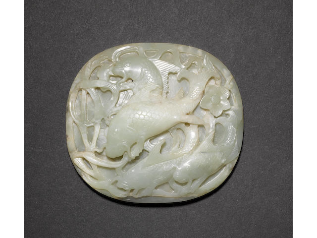 A jade plaque or applique of oval form, carved with four carp swimming through strands of marine foliage Ming Dynasty