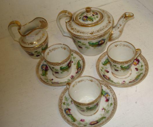 A Russian porcelain tea service, circa 1880, each piece painted with a band of pansy's within a gilt grape and vine boarder, comprising: teapot and cover, milk jug, nine cups and eight saucers. (19)
