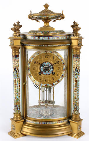 A late 19th/early 20th century French gilt brass and polychrome champleve oval section mantel clock