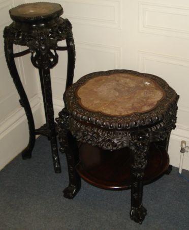 A Chinese foliate carved rosewood circular two tier cache pot stand, Qing dynasty, late 19th Century, with rouge royale marble inset top, on mask headed legs, with ball and claw feet, 63cm, and a taller similar example, on cabriole legs, 33cm. (2)