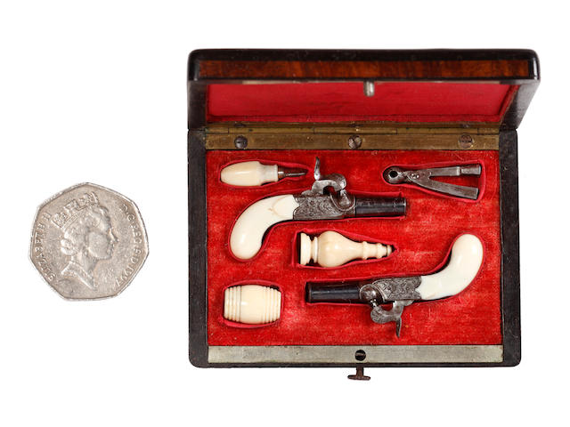 A Cased Pair of Continental Miniature Percussion Boxlock Pistols and a single Miniature Pinfire Pistol
