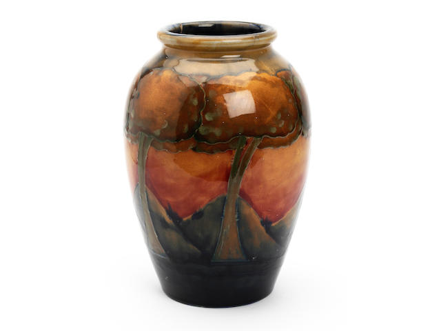 William Moorcroft 'Eventide' a vase,circa 1925 of ovoid form,with a continuous band of six trees 24.5cm high signed in blue and impressed, Moorcroft, Made in England. Rim cracked in three places, and repaired