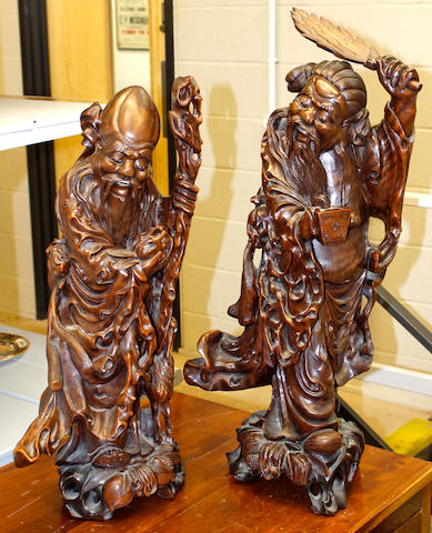 A pair of large Chinese hardwood carvings of taoist immortals