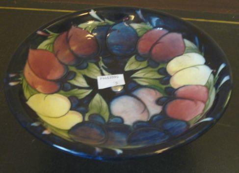 A Moorcroft dish, in the plum wisteria pattern, on chrome pedestal foot, 18cm diameter.