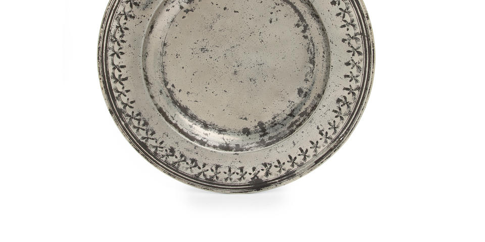 A fine and rare punch decorated broad-rim charger, circa 1690