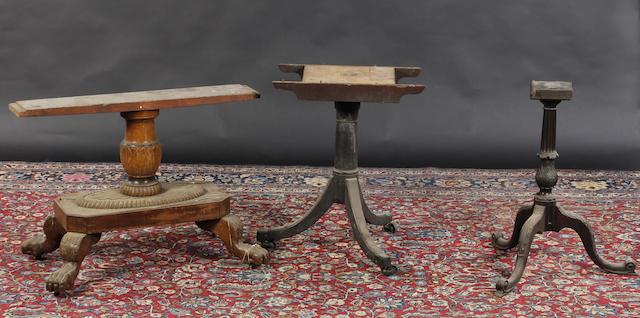 A Chippendale style carved mahogany tripod base with acanthus carving, together with a George III mahogany dining table pedestal, and a William IV style breakfast table base with paw feet.