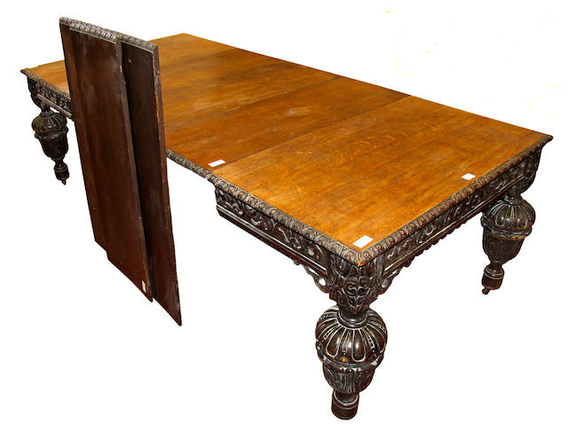 A Victorian heavy carved oak extending table and six leaves, the top with leaf carved edge and scroll frieze with pierced brackets, on substantial cup and cover legs, 356cm extended x 111cm wide.