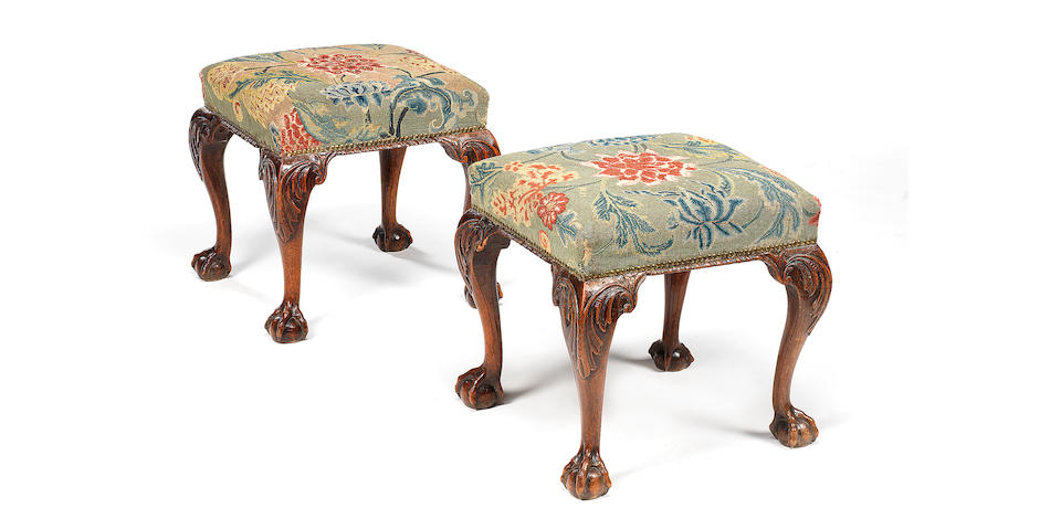 A pair of George II carved walnut stools