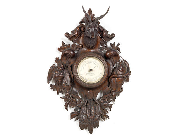 A late 19th century Black Forest style hunting trophy carved and stained oak aneroid barometer the dial signed M. Pillischer, 88 New Bond Street, London