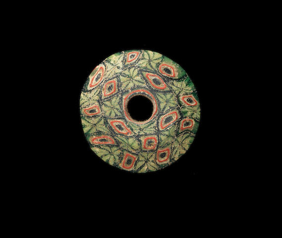 An Egyptian mosaic glass spindle whorl