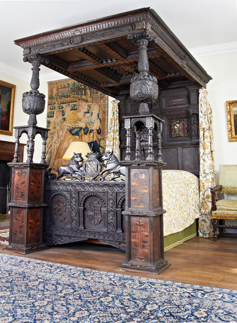 An impressive Elizabeth I oak and inlaid tester bed, circa 1580, bearing the coat of arms of the Ratcliffes of Ordsall Hall, Lancashire, incorporating some associated and some later elements