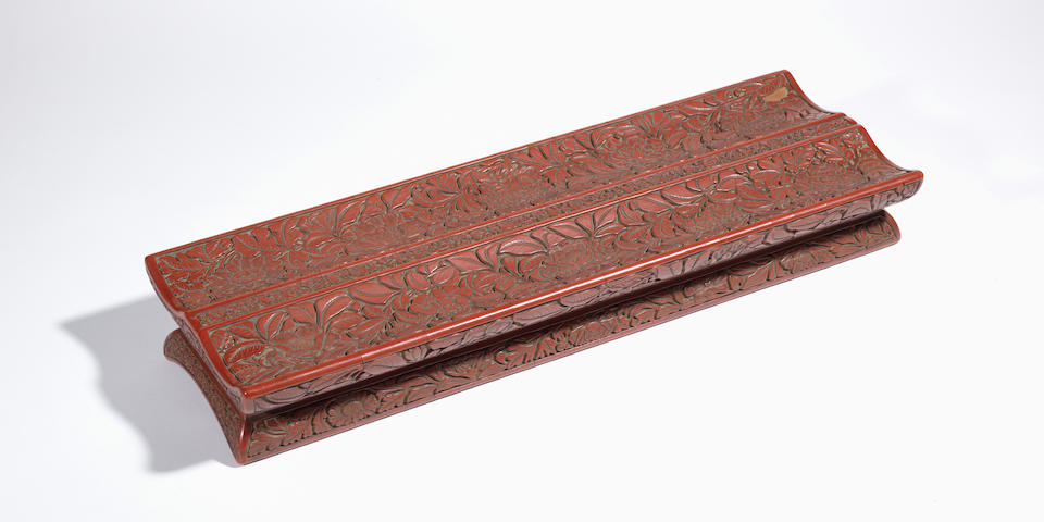 An extremely rare large cinnabar lacquer 'flowers' scroll-rest Early Ming Dynasty, 15th century