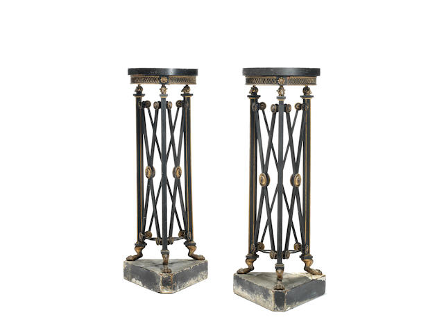 A pair of Regency ebonised and parcel gilt triform torchere stands in the manner of Thomas Hope