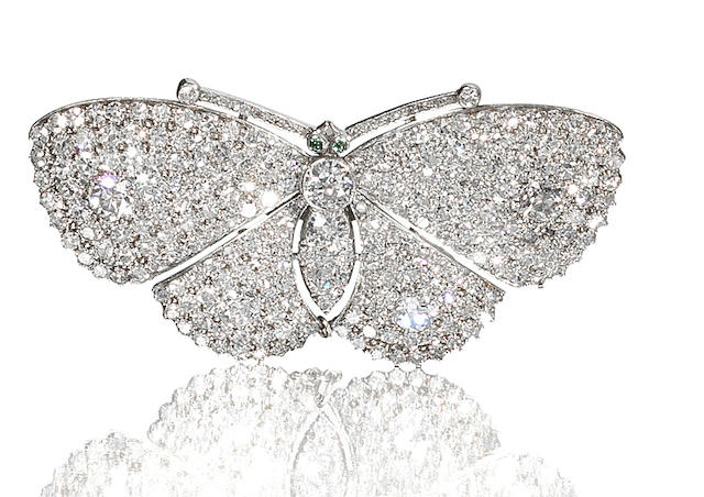 A diamond and emerald butterfly brooch,