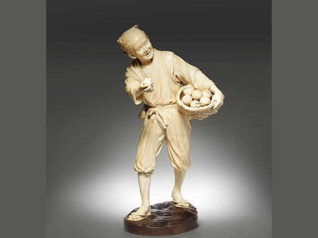 A fine and exceptionally tall ivory okimono figure of a fruit seller Meiji Period