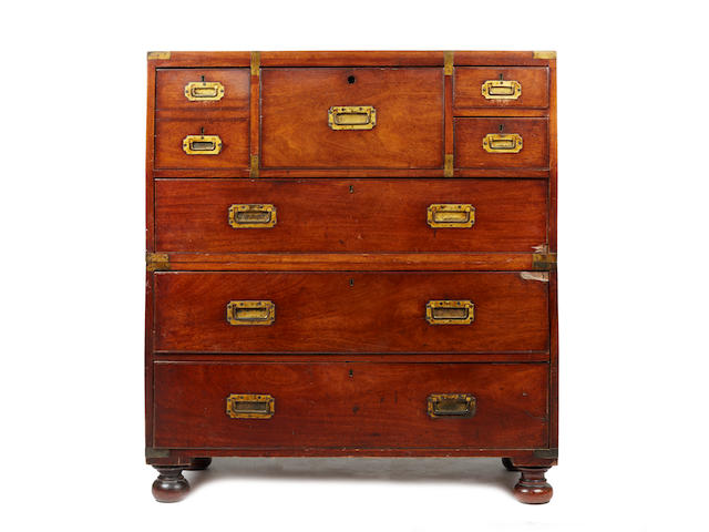 A Victorian teak brass bound campaign secretaire chest,in two parts, the central hinged fall front dummy drawer enclosing small drawers and pigeon holes, flanked by one deep drawer disguised as two and two shallow drawers with three long drawers below, on turned bun feet, 102cm.Originally the property of Edward Elphinstone Mahon, physician