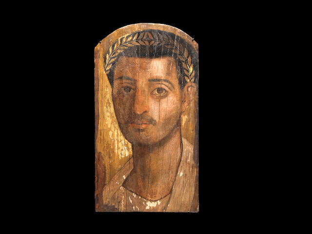 An Egyptian encaustic painted and gilt wood mummy portrait of a man
