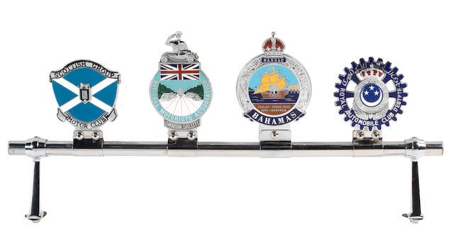 A badge bar fitted with four enamel motoring badges,