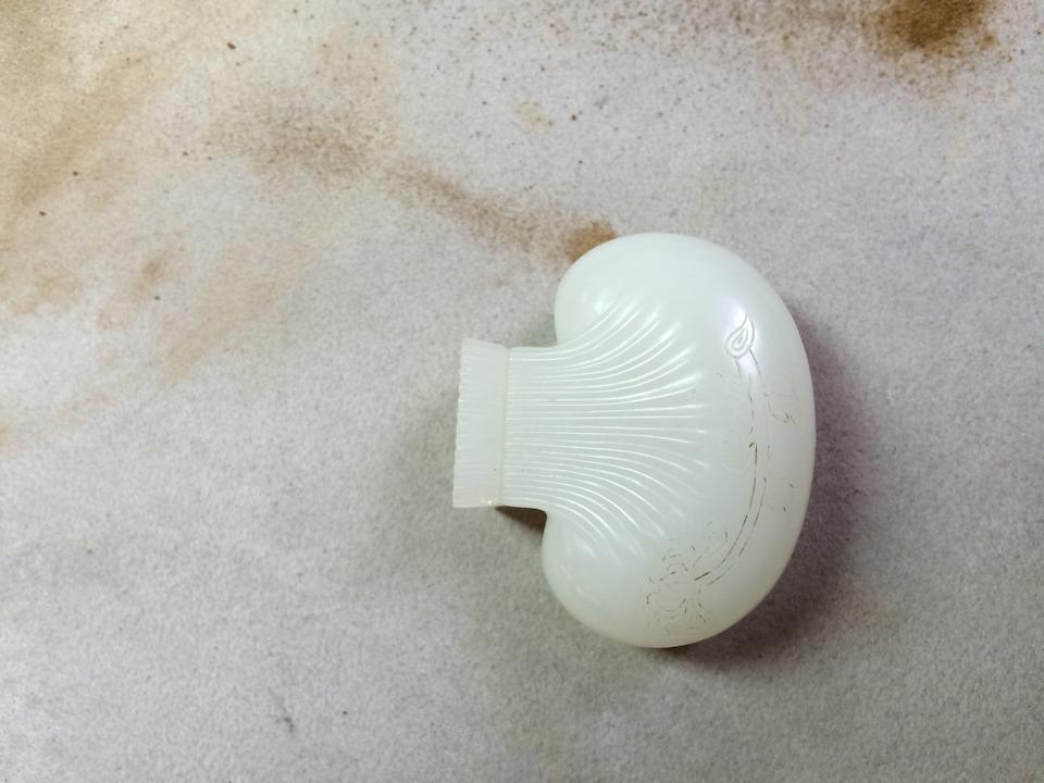 A carved Chinse white jade purse-form snuff bottle