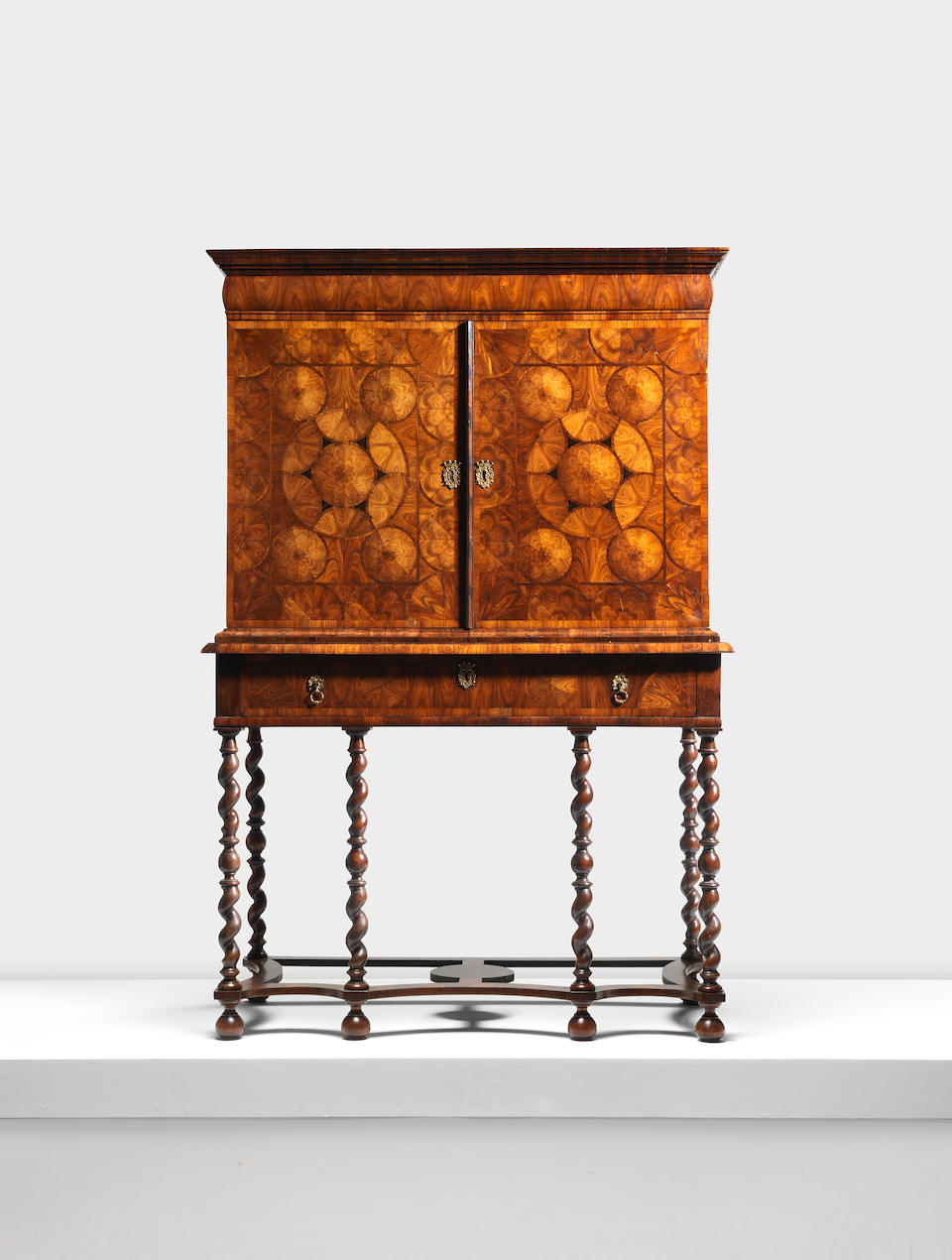 A William and Mary kingwood, oyster veneered and ebony inlaid cabinet on a later stand Circa 1690, the cabinet in the manner of Thomas Pistor