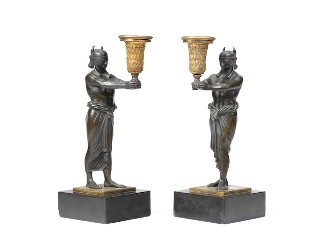 A pair of Empire patinated and gilt bronze candlesticks