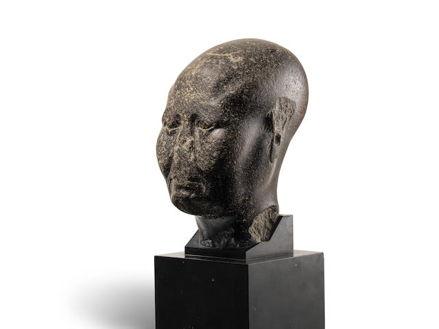 An Egyptian basalt head of a priest