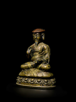 A COPPER AND SILVER INLAID BRASS FIGURE OF CHOKYI PALSANG TIBET, 15TH/16TH CENTURY image 1